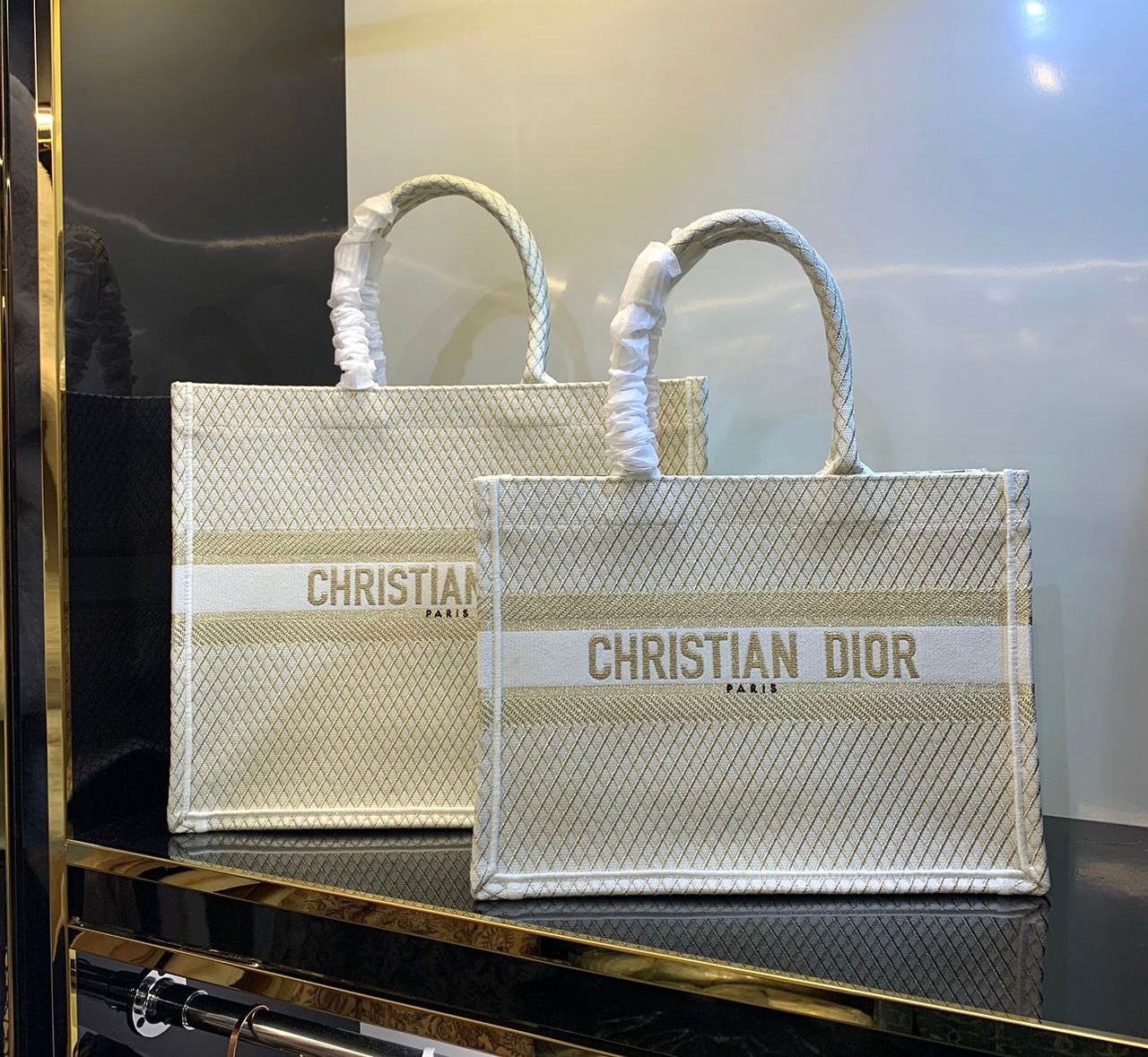 Dior Book Tote bags featuring a gold-tone Dior Oblique motif and the "Christian Dior Paris" signature. image 1