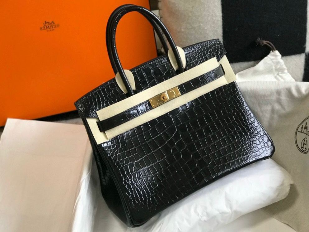 Herm?s Birkin 25 bag in black shiny crocodile or alligator leather with gold hardware. image 1