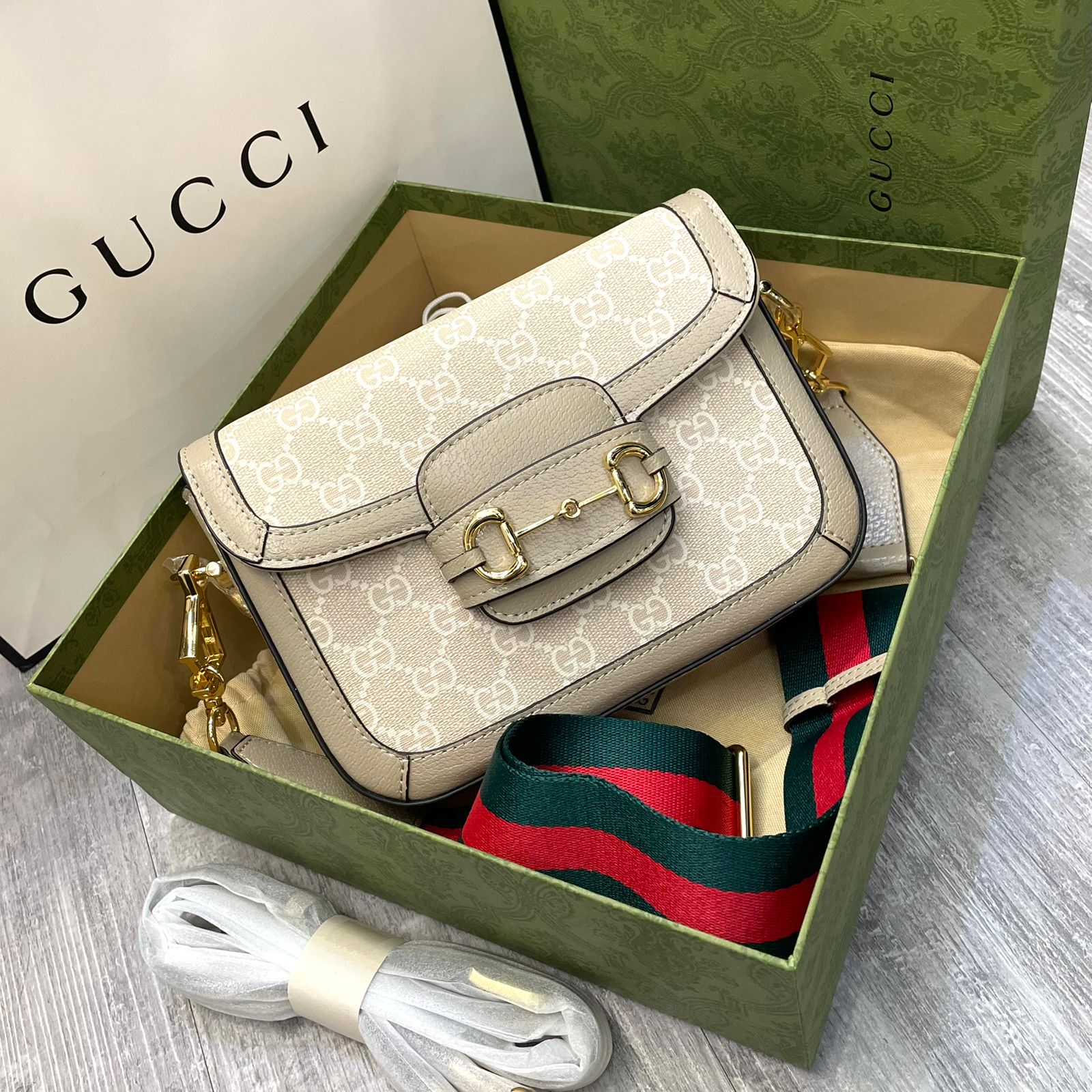Gucci Horsebit 1955 GG Mini Bag in beige and white GG Supreme canvas with a gold-tone horsebit detail and a detachable red and green Web strap. image 1