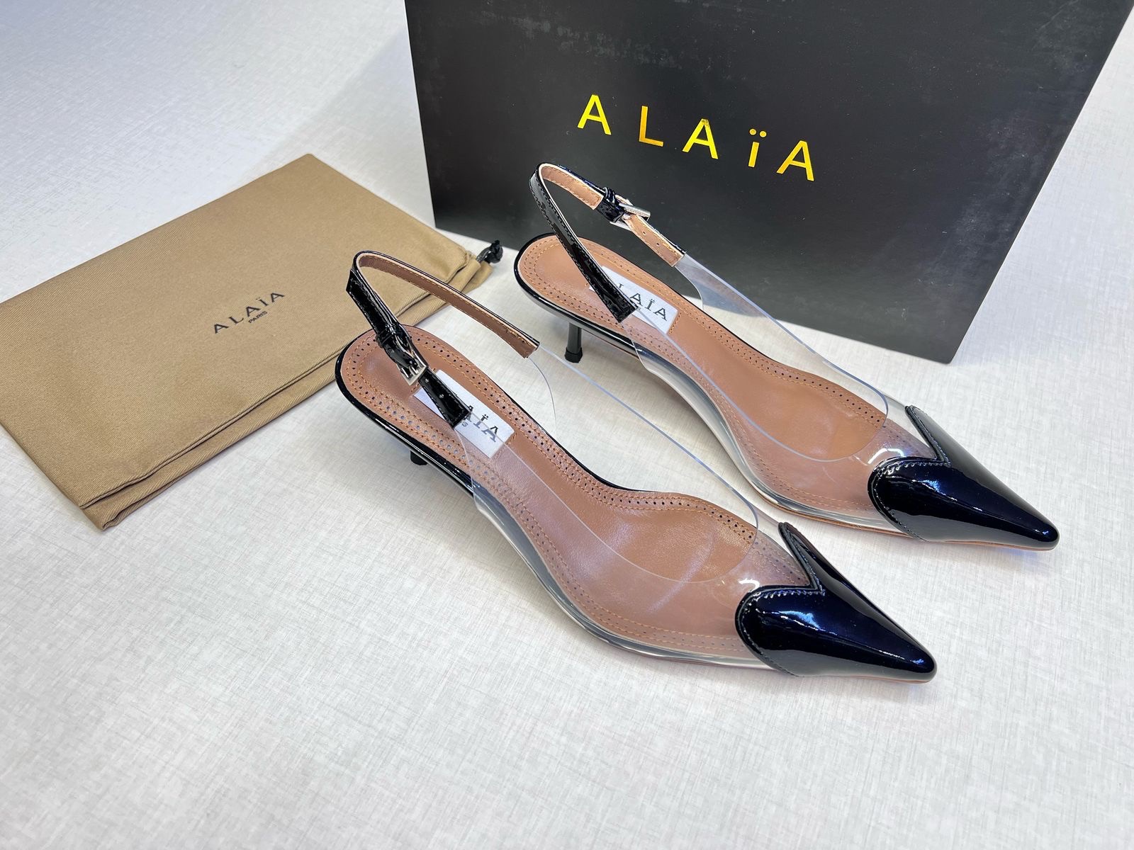 Alaïa Le Cœur slingback pumps in black patent leather and clear polyurethane (PVC) with a 55mm heel. image 1