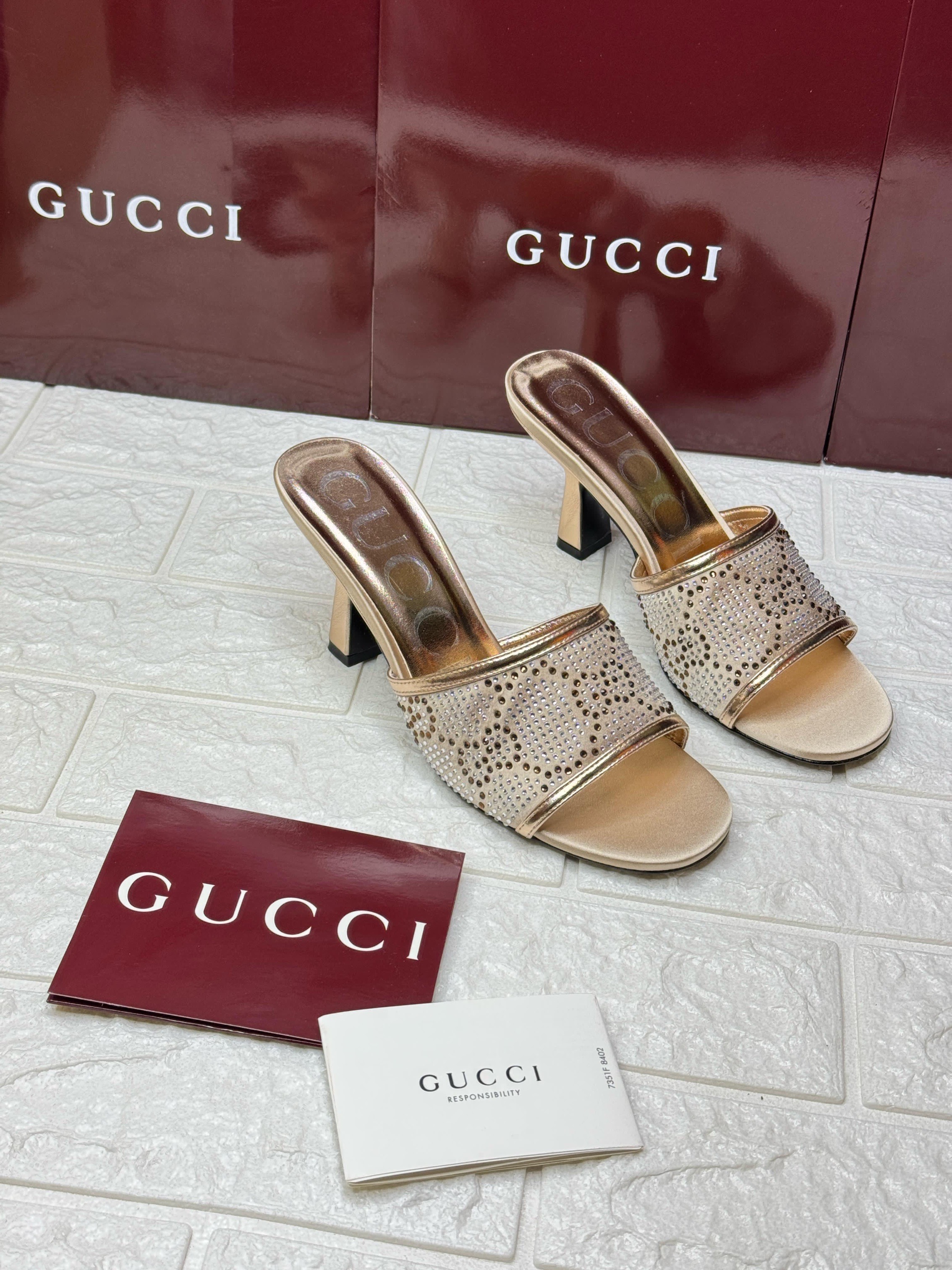Gucci mid-heel slide sandals in a metallic gold finish with crystal embellishments. image 1