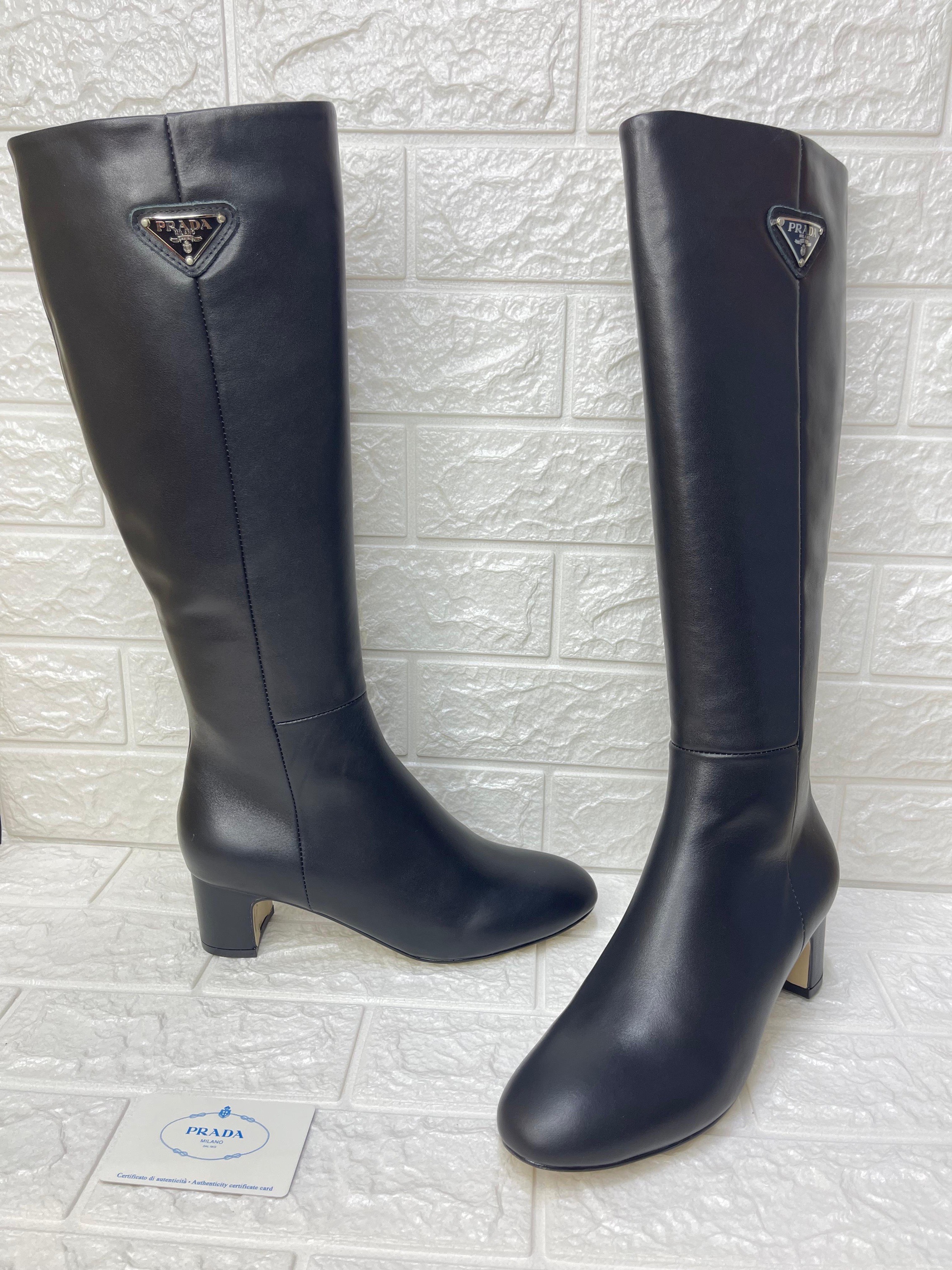 Prada black leather knee-high boots with an enamel triangle logo. image 1