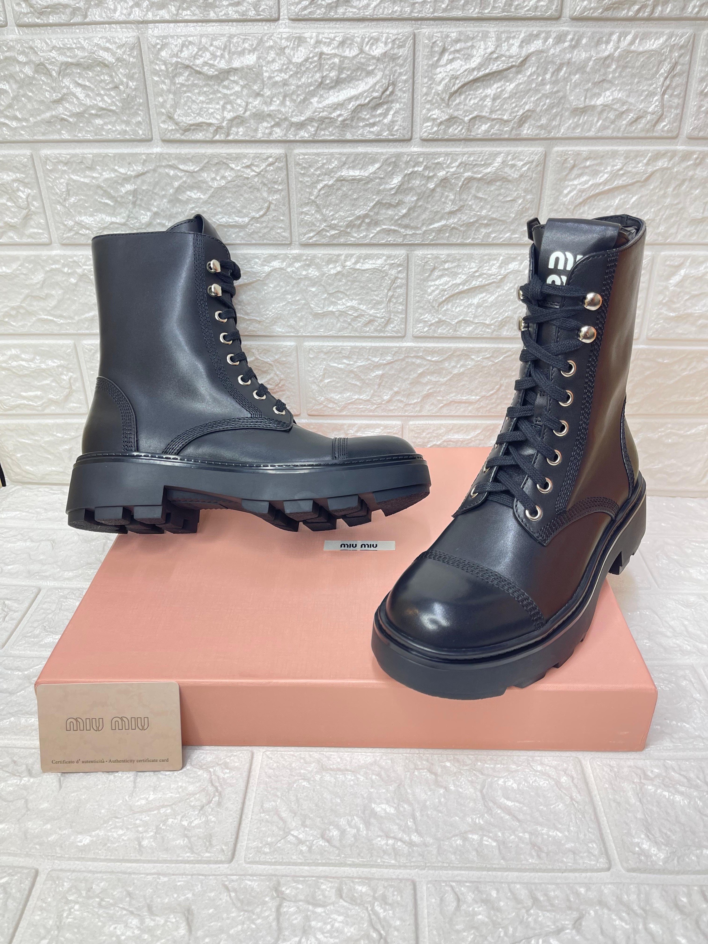 Miu Miu black leather lace-up combat boots with a lug sole. image 1