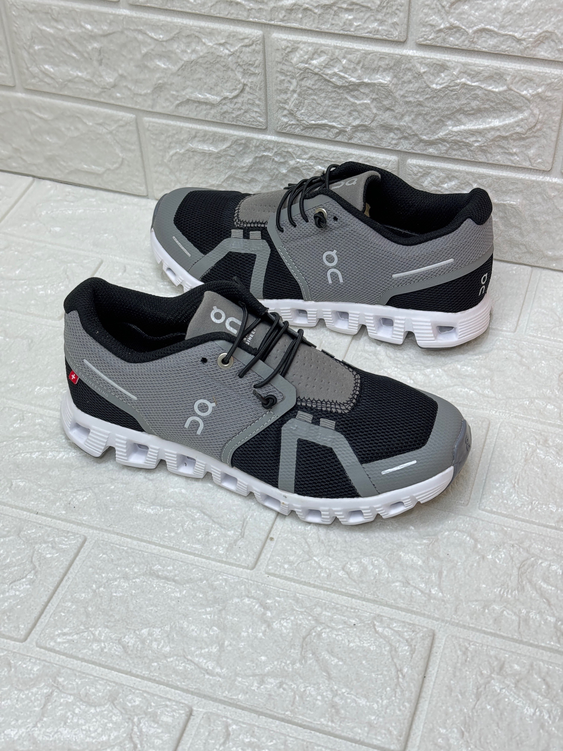 On Cloud 5 running shoes in black and dark grey. image 1