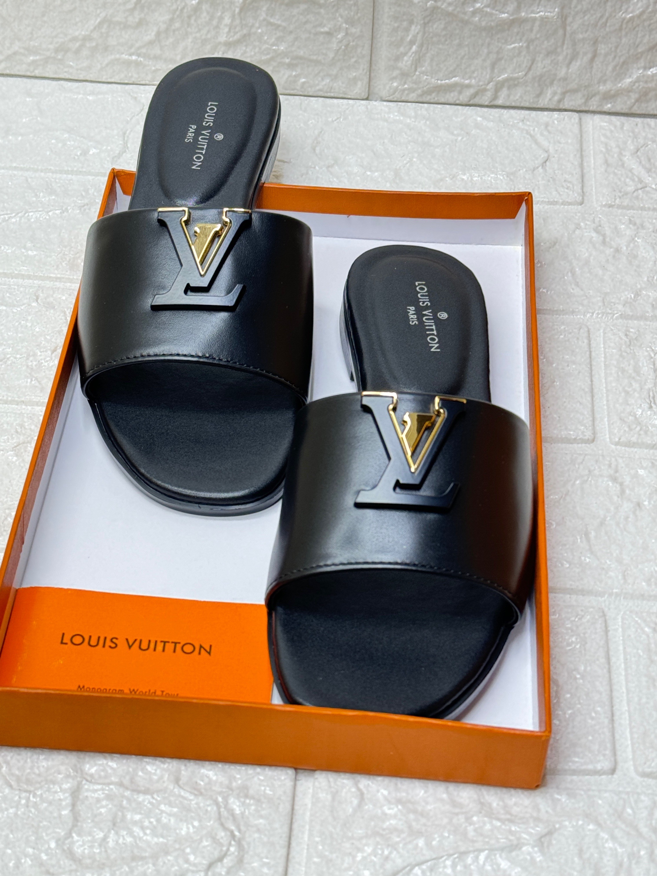 Louis Vuitton LV Mare flat mule slipper in black calf leather with a gold-tone LV Initials accessory. image 1