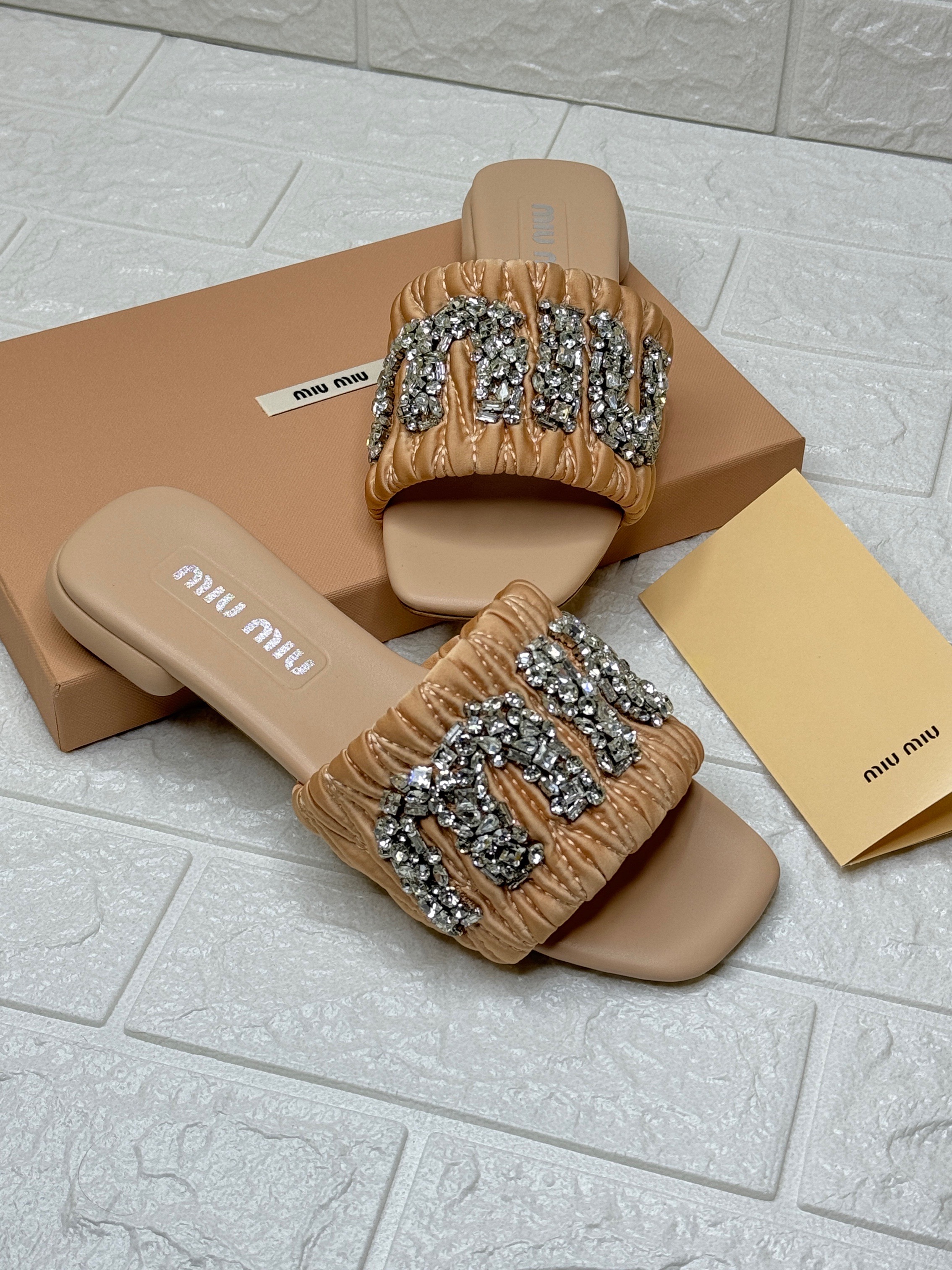 Miu Miu logo-patch raffia slide sandal in camel brown with crystal embellishments. image 1