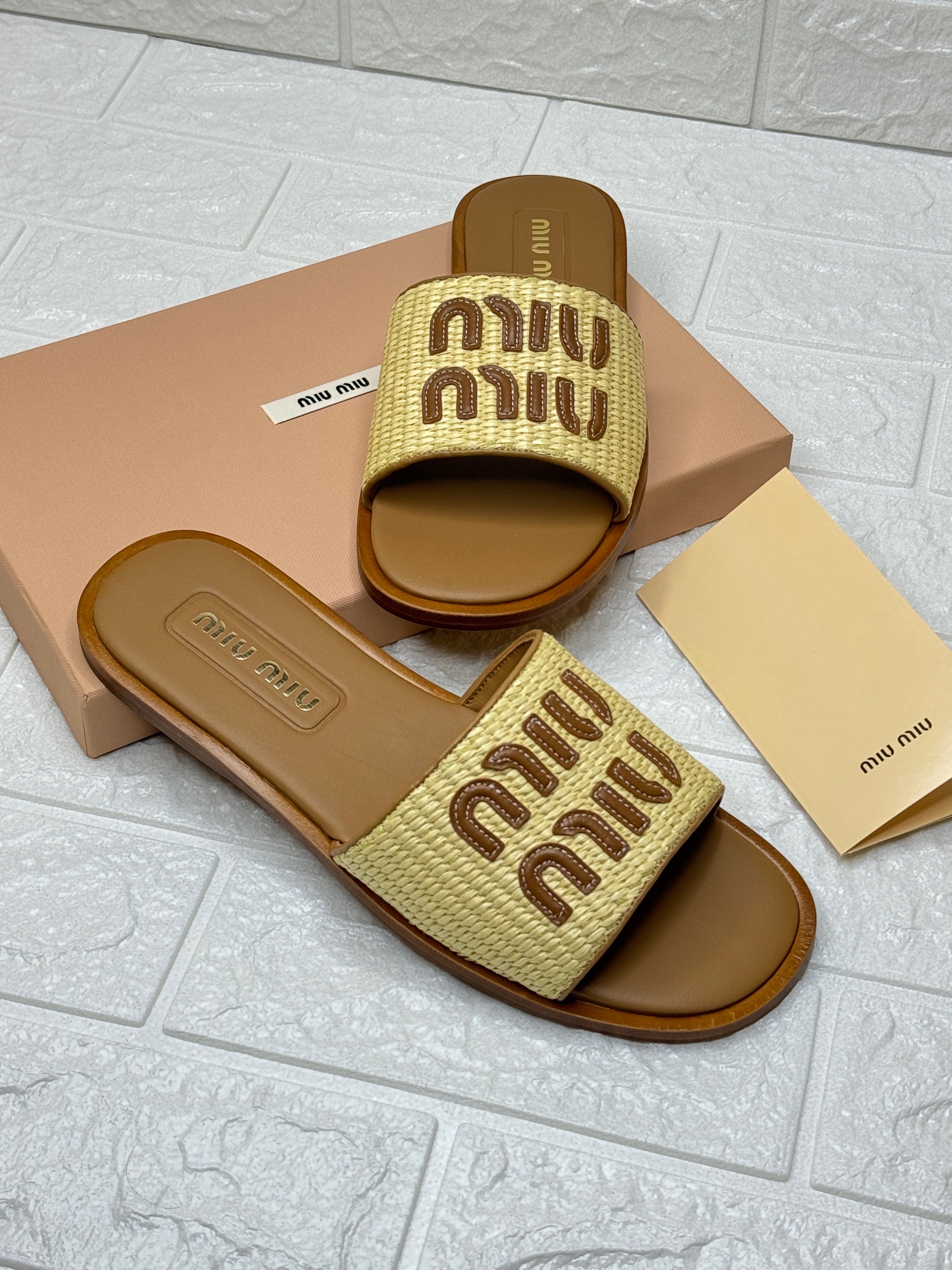 Miu Miu logo-patch raffia and leather slides in a camel brown color. image 1