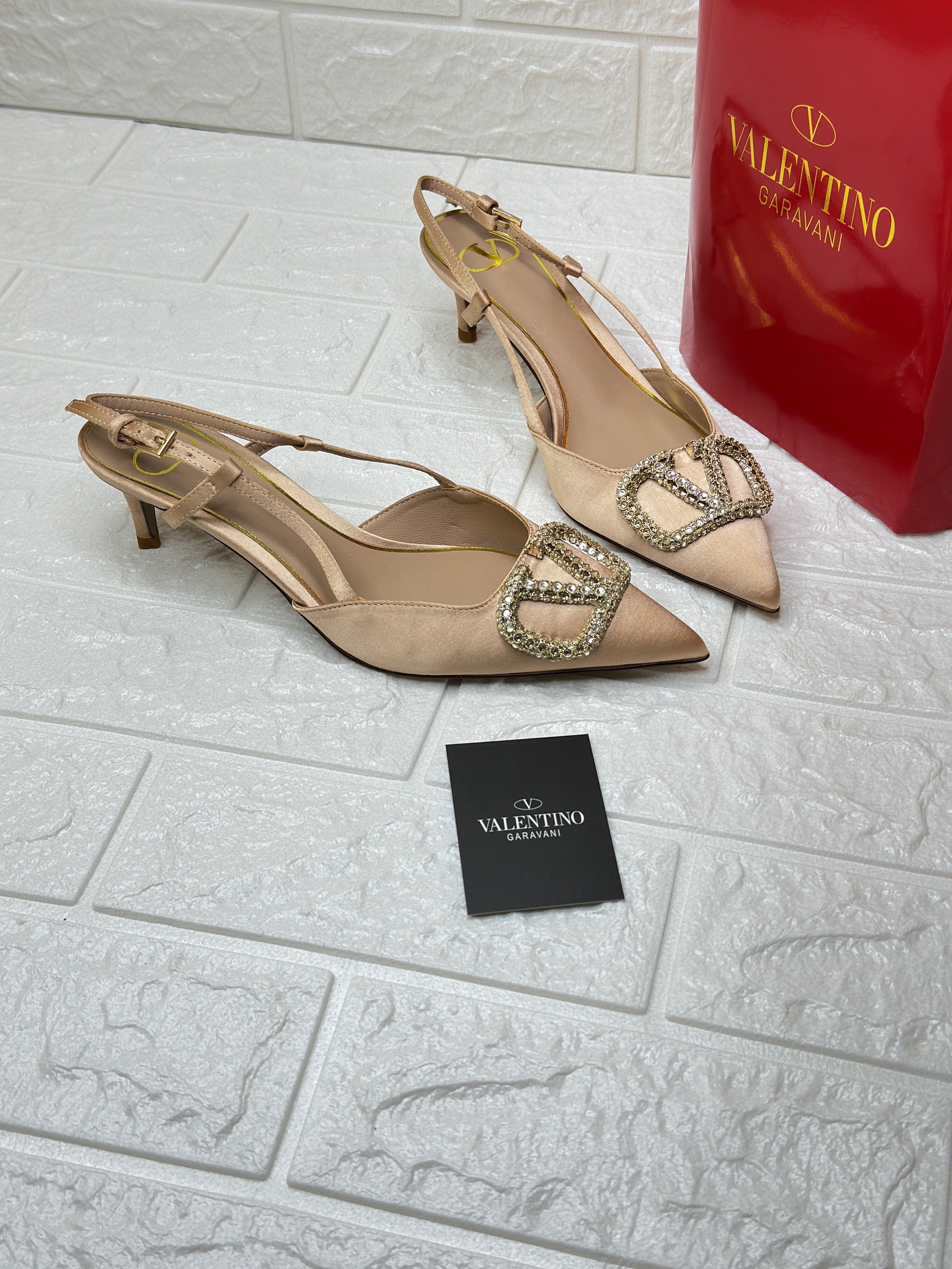 Valentino Garavani VLogo Signature slingback pumps in a beige or nude color with crystal embellishment. image 1