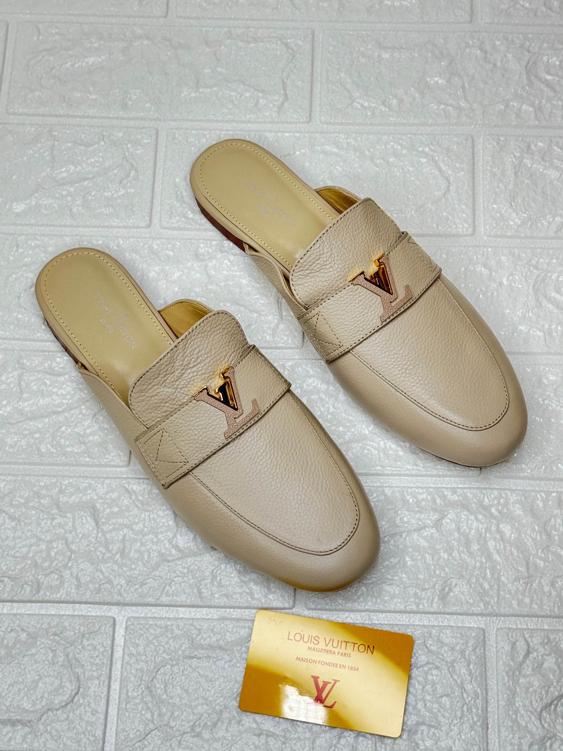 Louis Vuitton Capri or LV Mare open-back loafer in a beige or pink-beige calf leather with a gold-tone LV Initials accessory. image 1