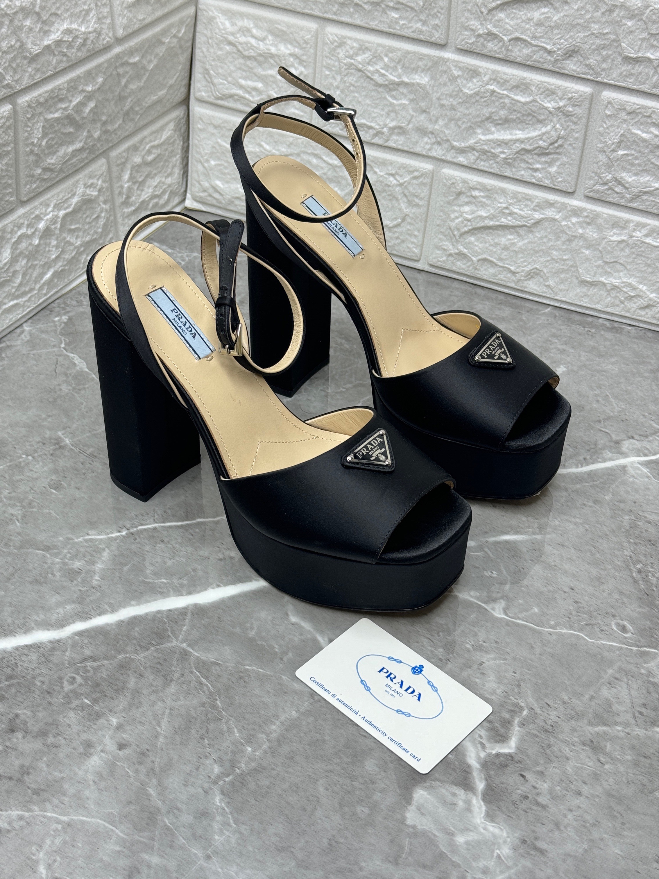 Prada black satin platform sandals featuring an enamel metal triangle logo. image 1
