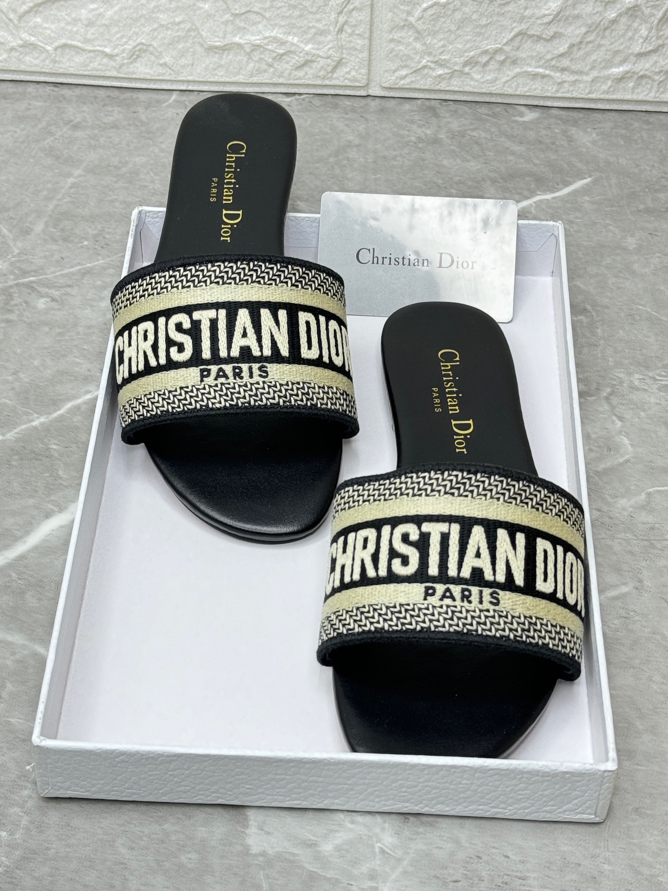 Christian Dior Dway slide sandals in black with the "Christian Dior Paris" signature embroidered on the strap. image 1