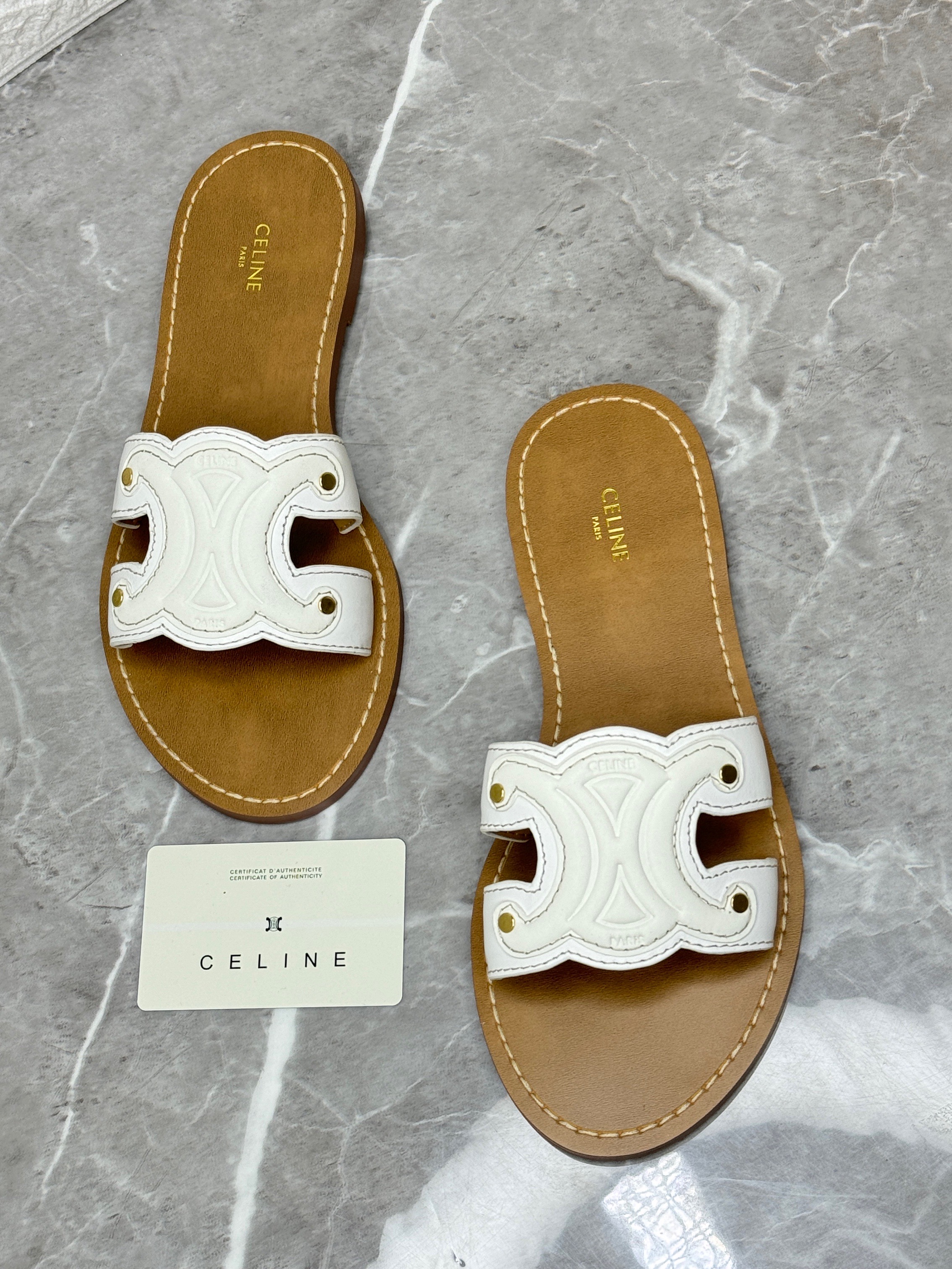 Celine Triomphe flat sandals in white leather. The iconic Triomphe leather patch is featured on the upper of the shoe. image 1
