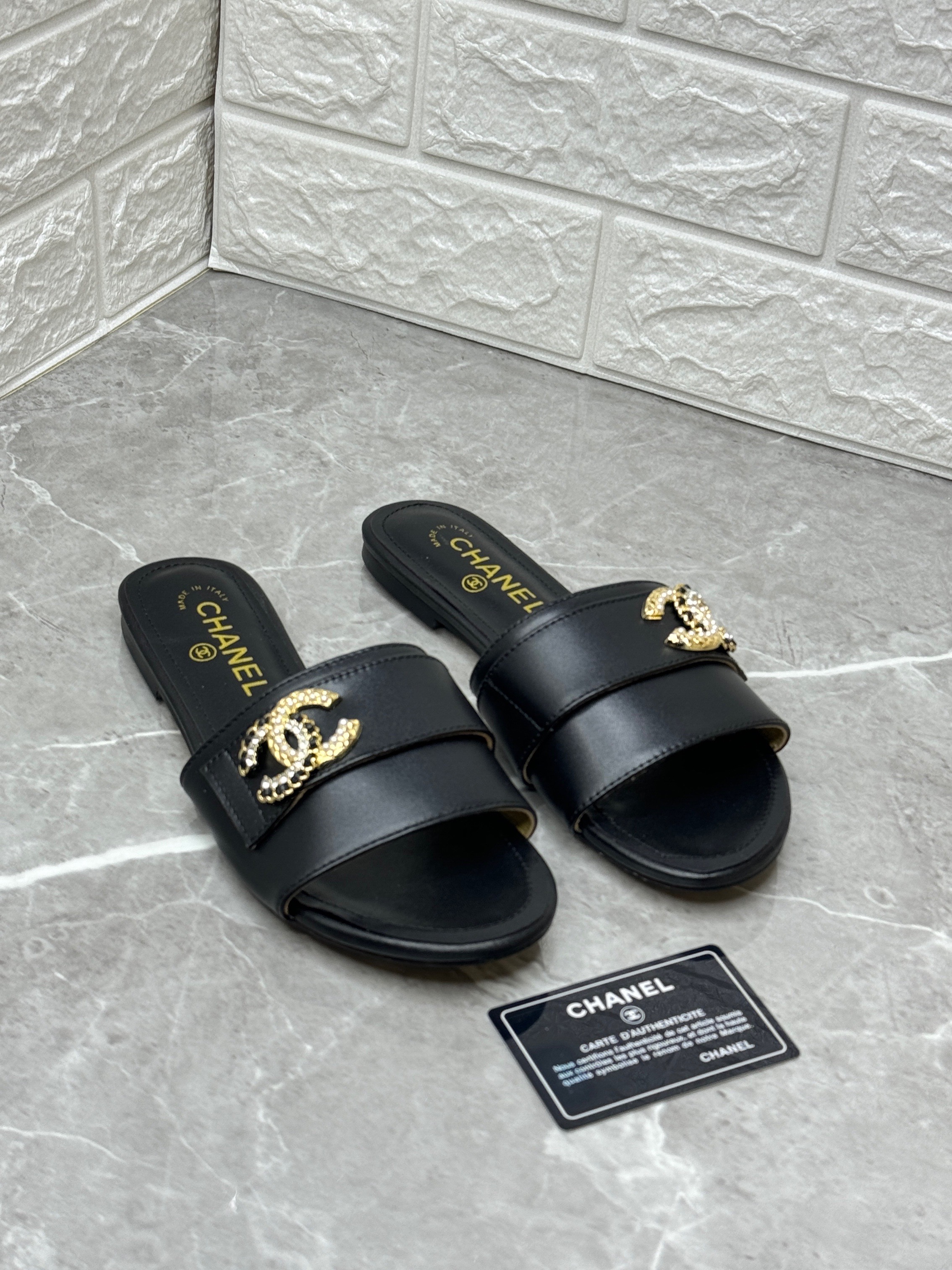 Chanel black leather slide sandals with a gold-tone CC logo embellishment. image 1