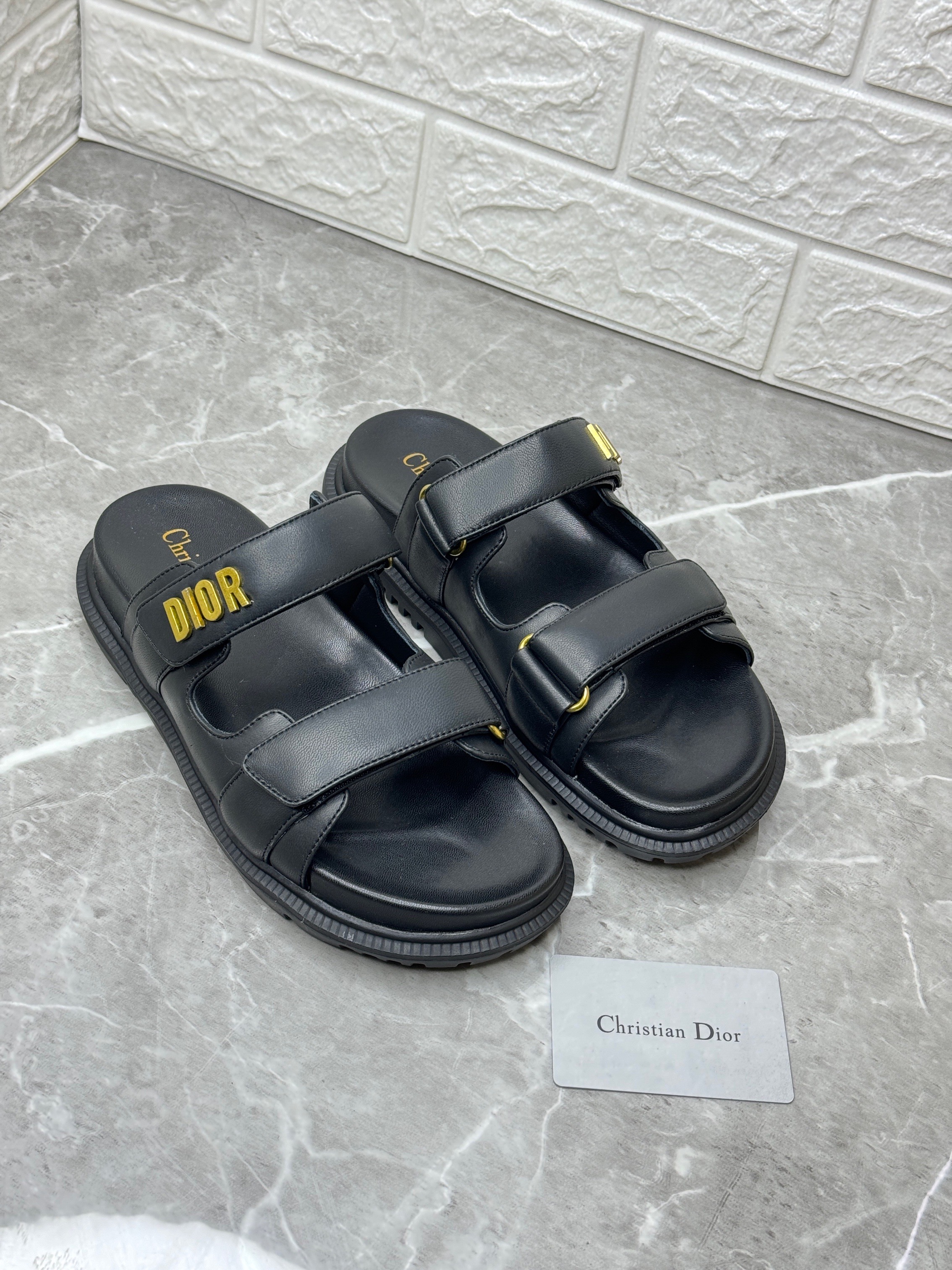 Christian Dior Dioract slide sandals in black lambskin with a gold-finish "Dior" signature. image 1