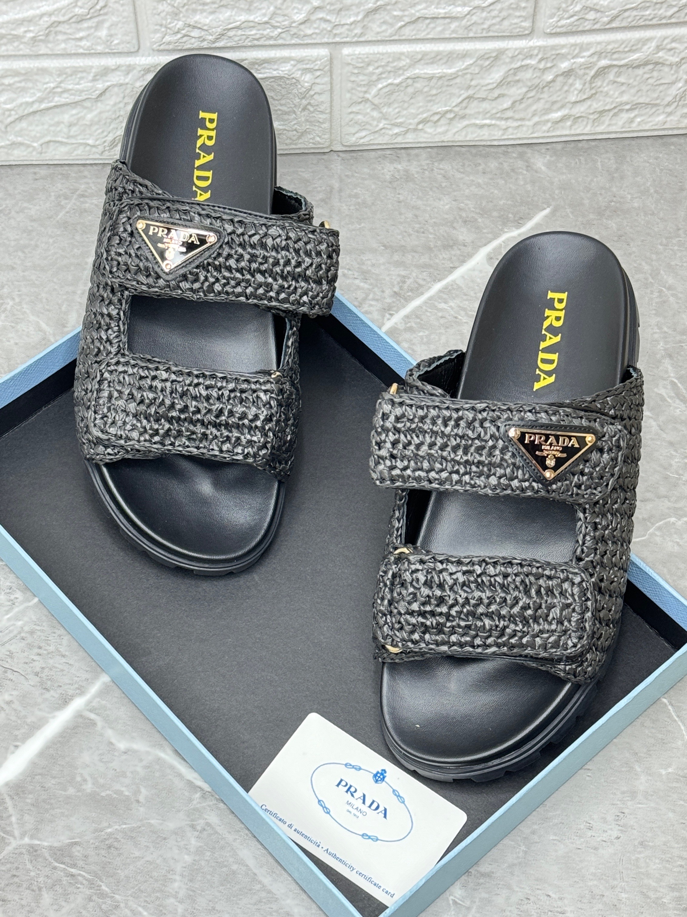 Prada black crochet sandals made from raffia-effect yarn with an enamelled metal triangle logo and a chunky rubber sole. image 1