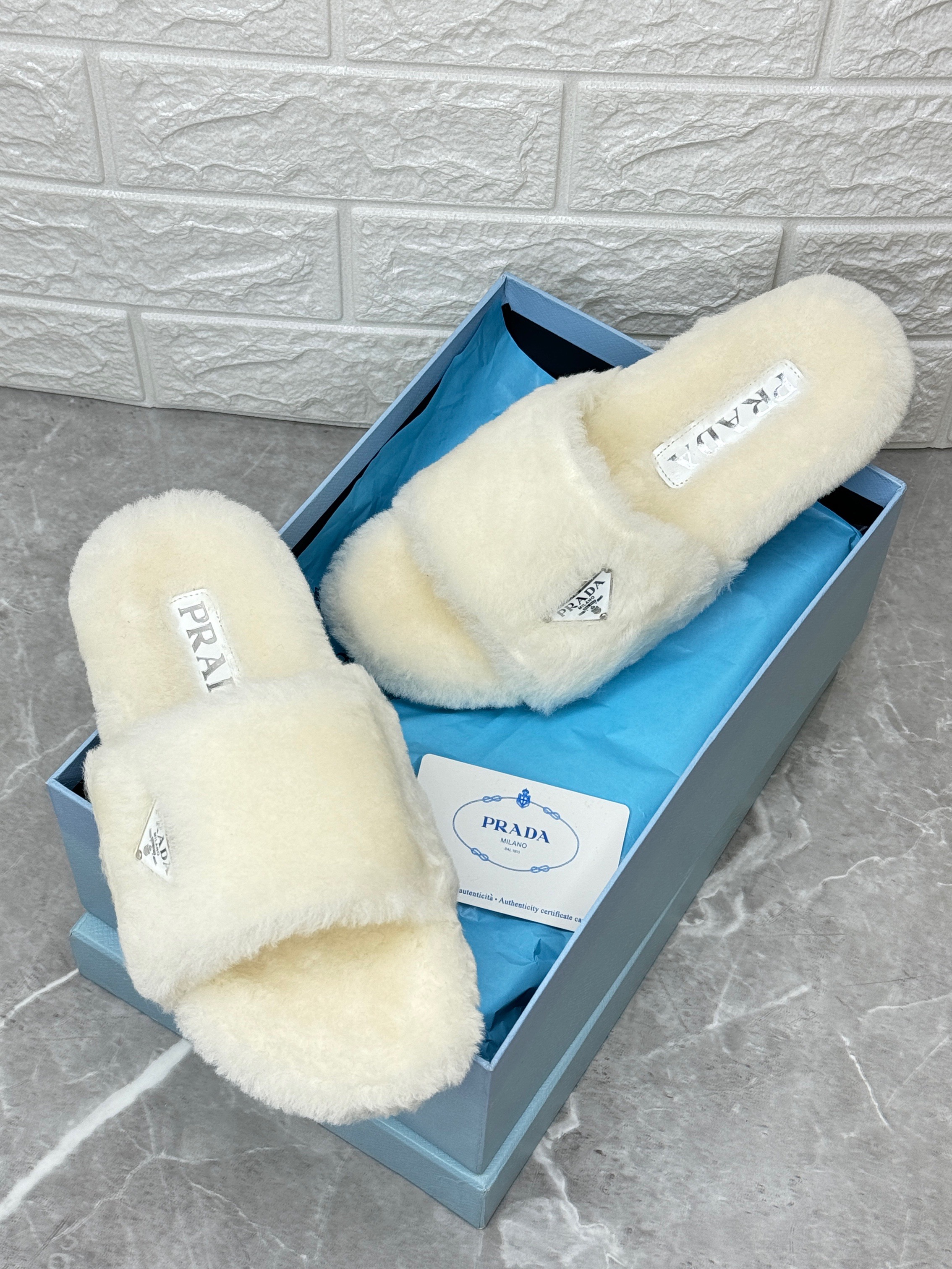 Prada shearling or faux fur slides in white or cream. image 1