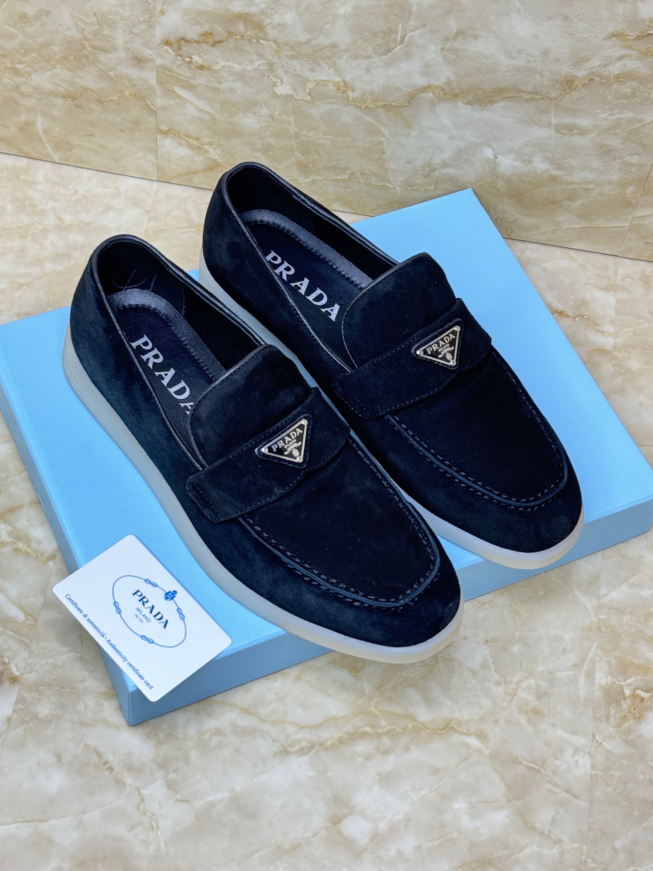 Prada suede loafers with a contrasting rubber sole and the brand's enameled metal triangle logo on the vamp. image 1