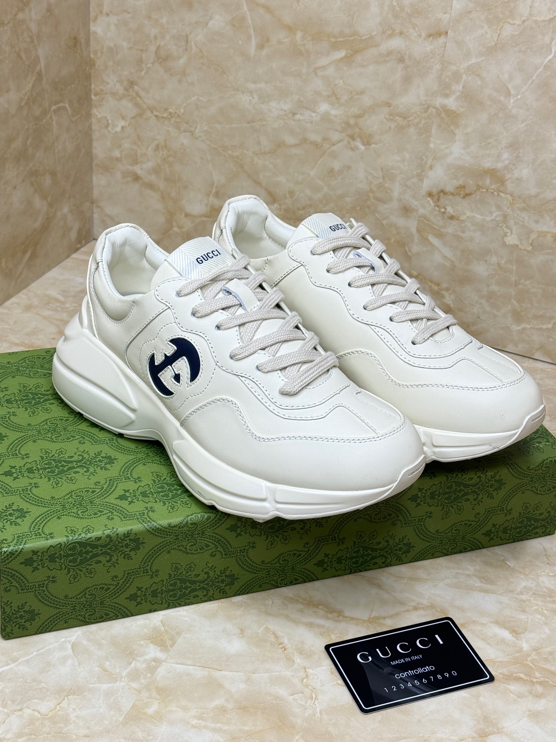 Gucci Rhyton sneakers in ivory leather with a navy-blue interlocking G logo cut-out at the sidewall. image 1