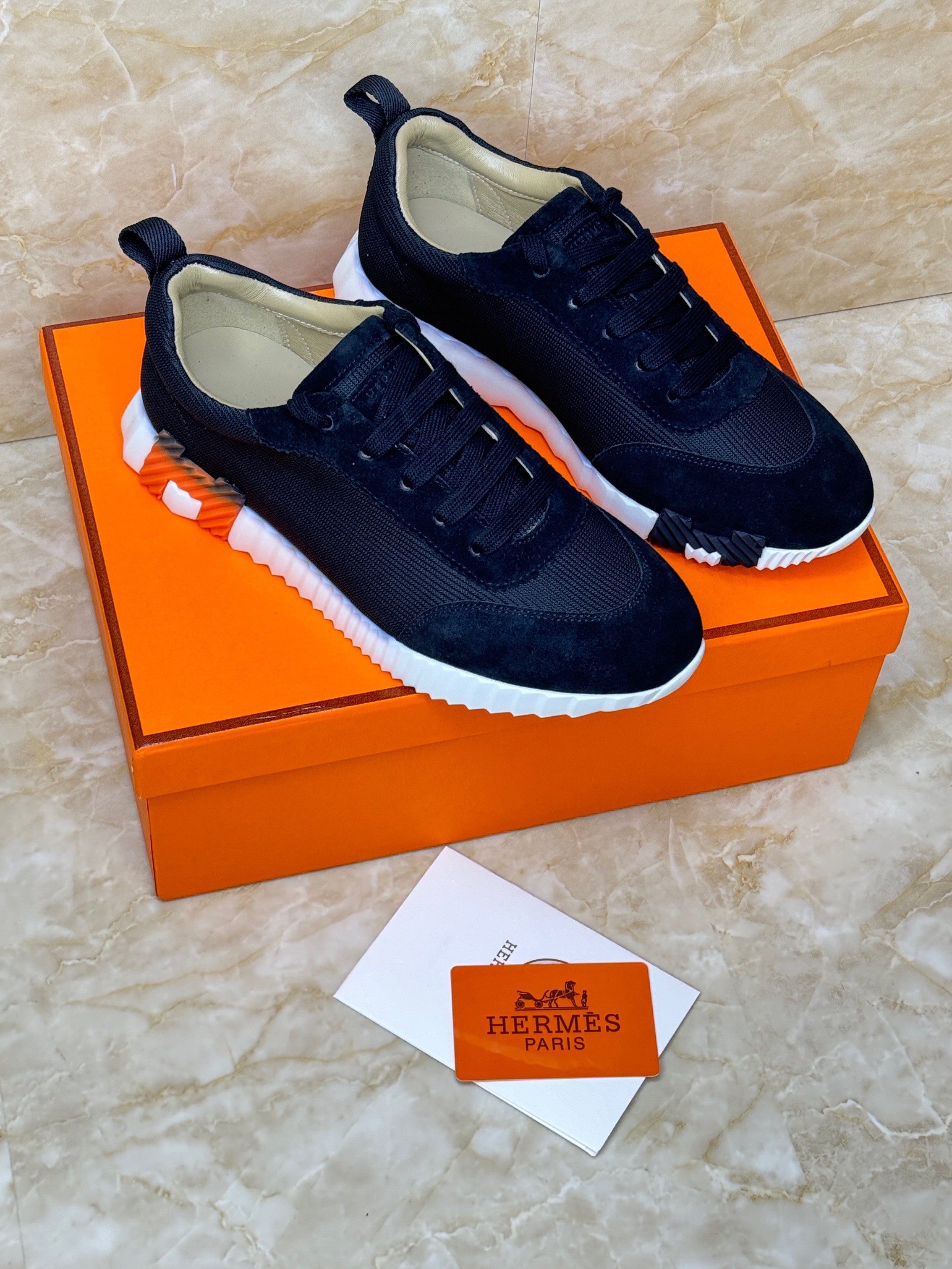 Herm?s Bouncing sneakers in black technical mesh and suede goatskin with white soles and orange details. image 1