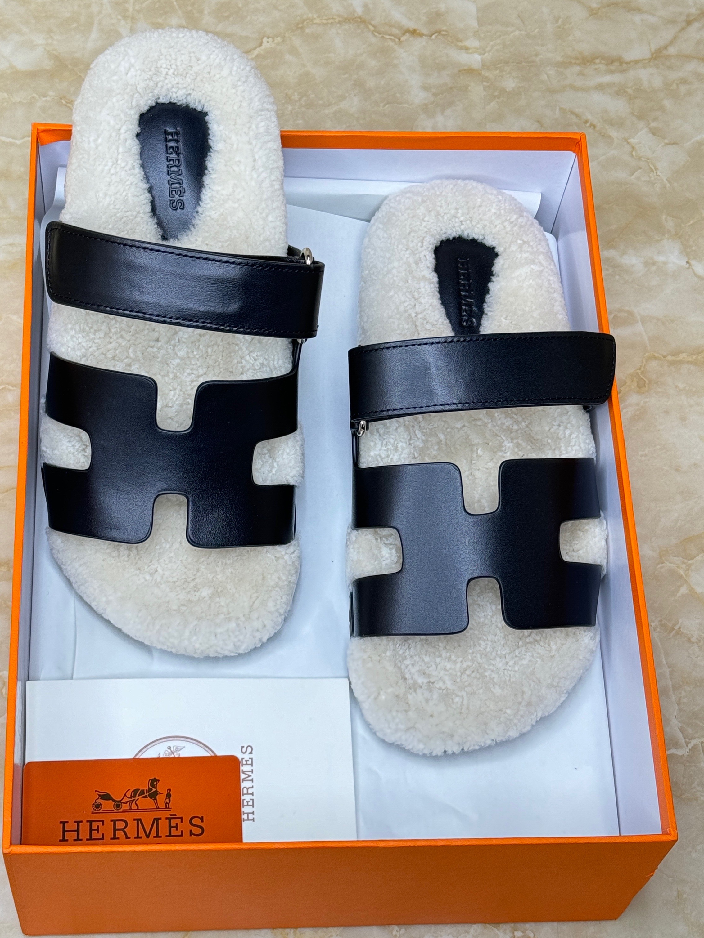 Herm?s Chypre sandals crafted in black calfskin leather and lined with shearling. image 1