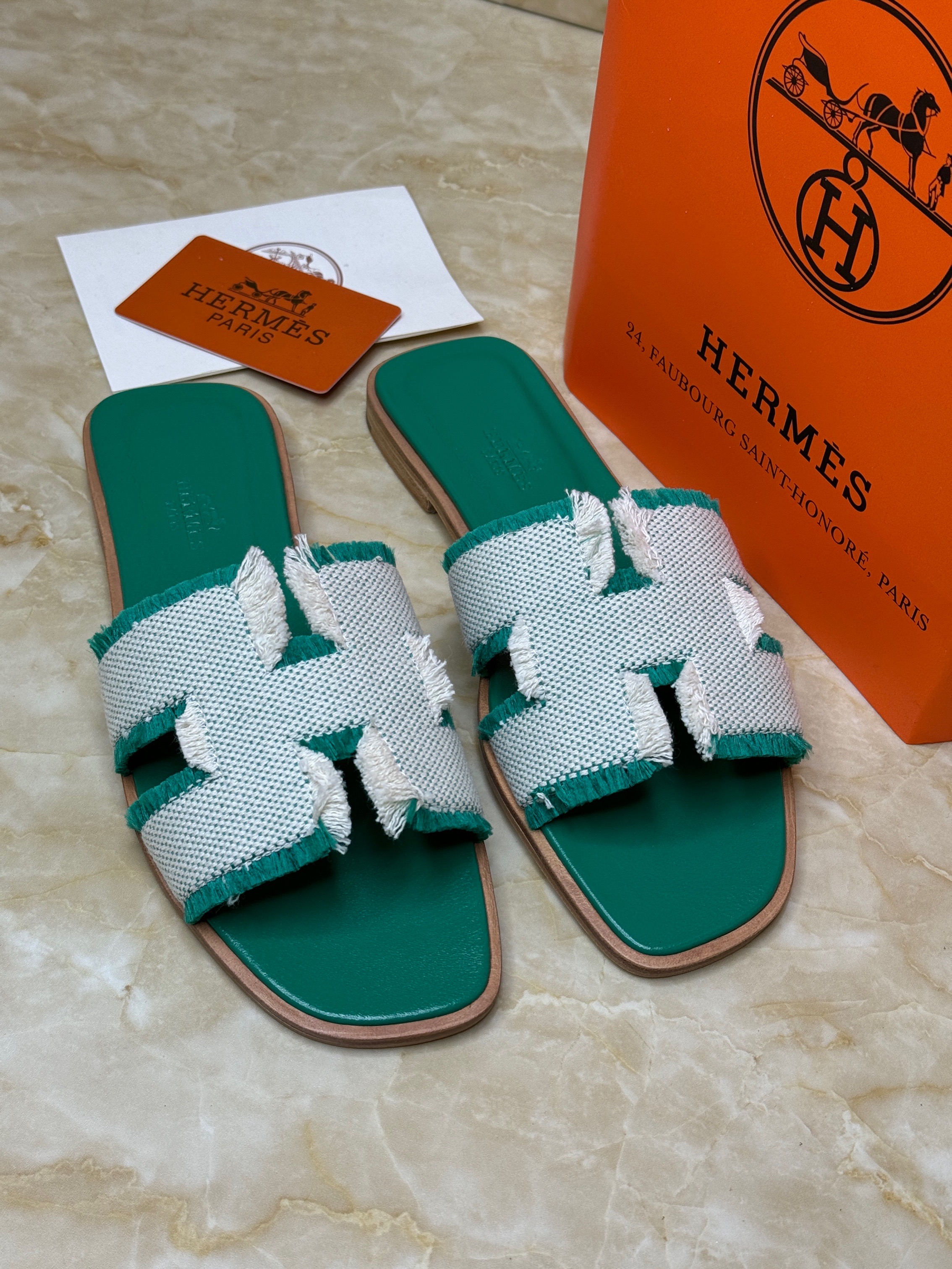 Herm?s Oran sandals with a green sole and a white fringed linen "H" cut-out strap. image 1