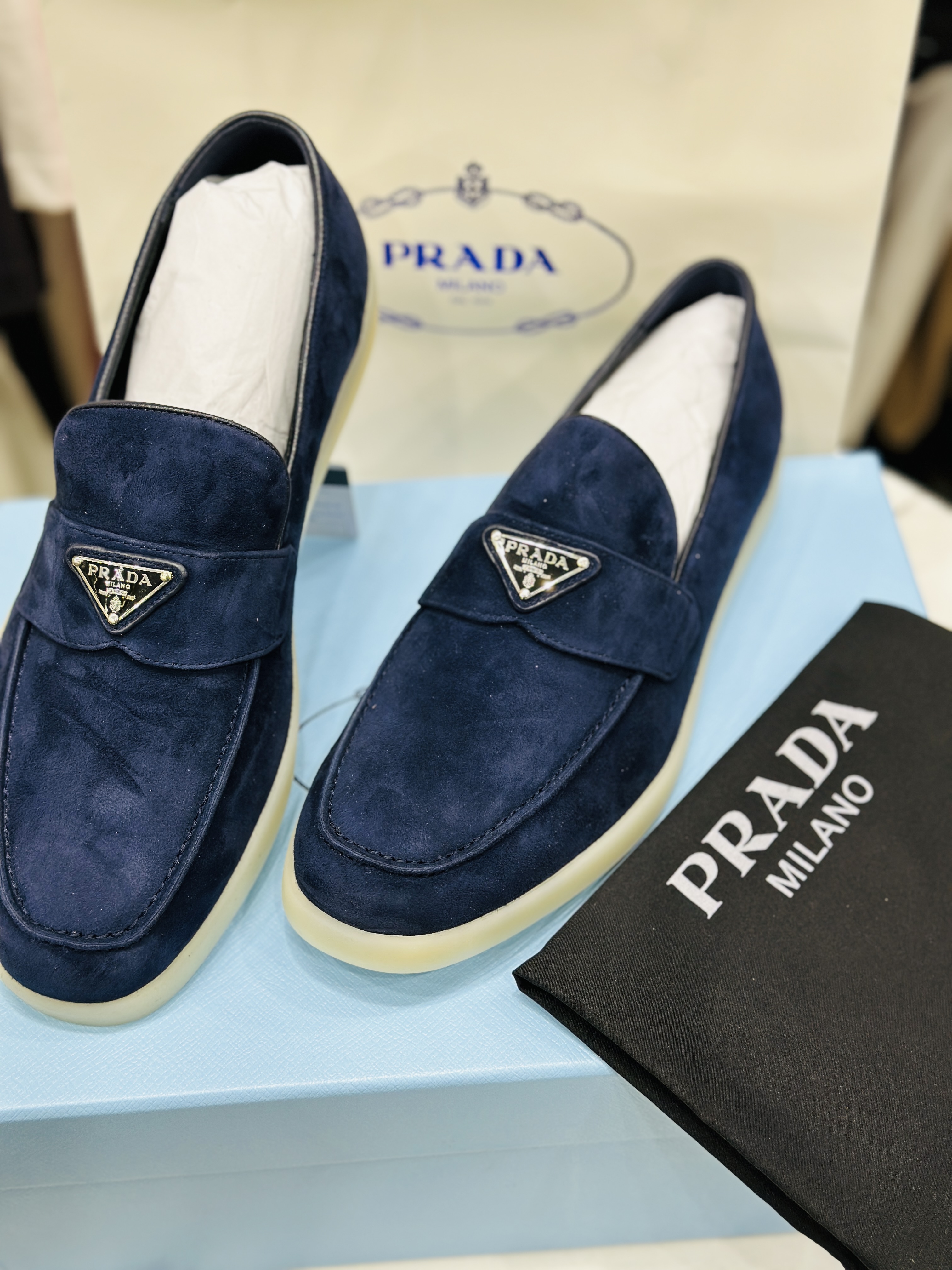 Prada suede loafers with an enameled metal triangle logo and a rubber sole. image 1