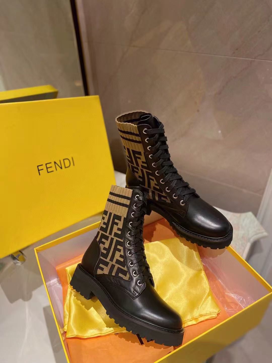 Fendi Rockoko knit leather combat boots in black with the signature brown and beige FF motif stretch-knit fabric cuff. image 1