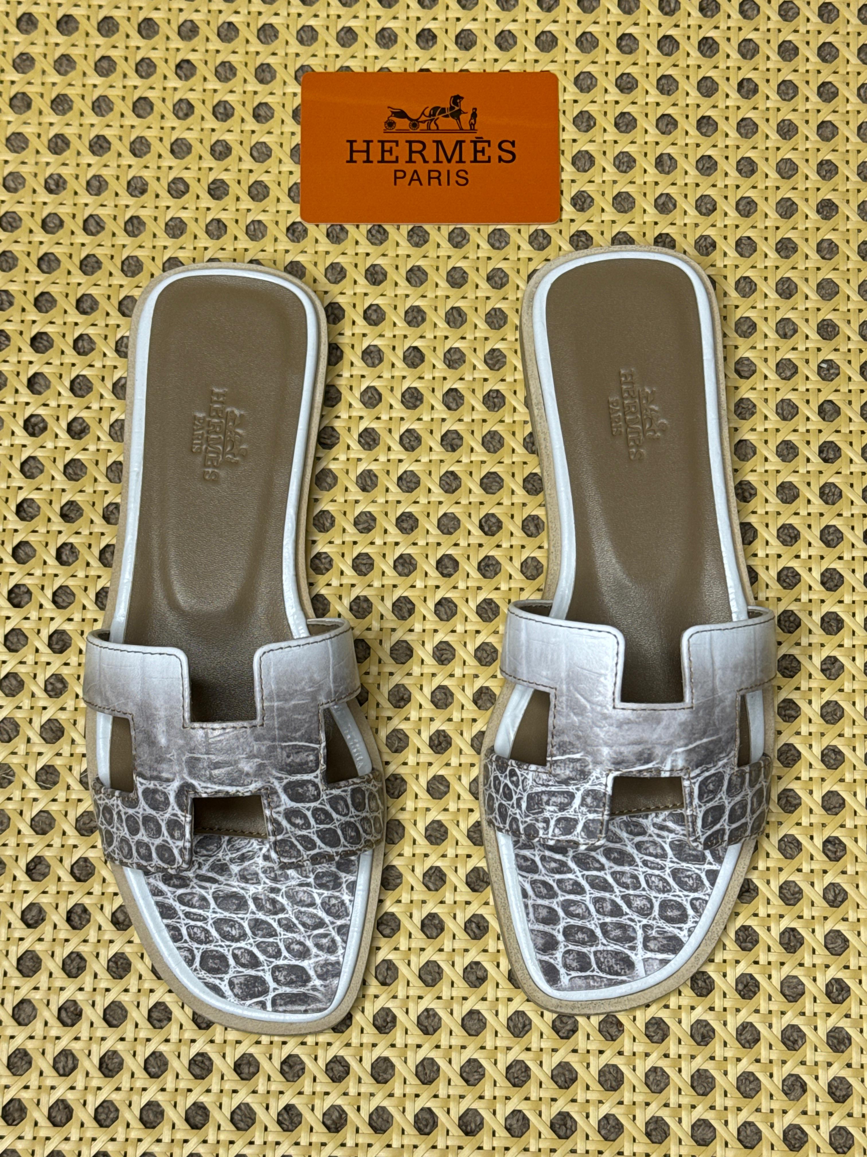 Herm?s Oran sandals with the iconic "H" cut-out design, likely in a crocodile or alligator leather finish. image 1